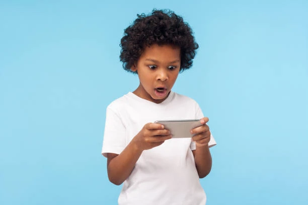 A child enjoying a game on a smartphone against a blue background